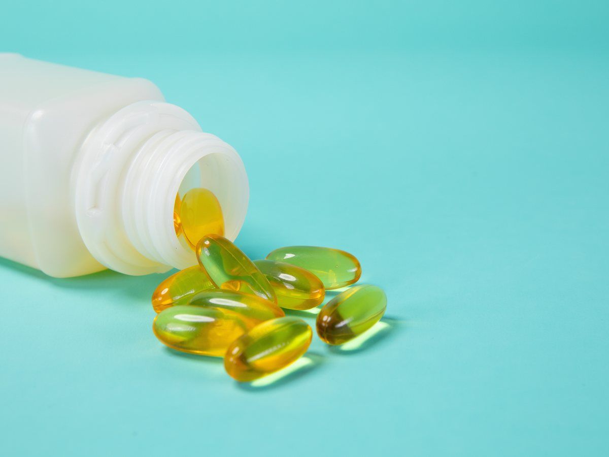 Supplement capsules beside an open bottle