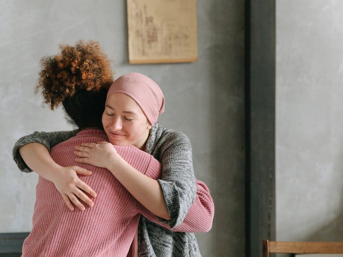 A cancer patient being comforted with a hug